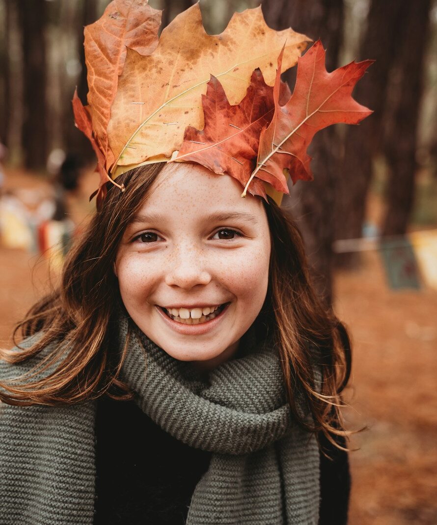Young girl wearing a crown of autumn leaves